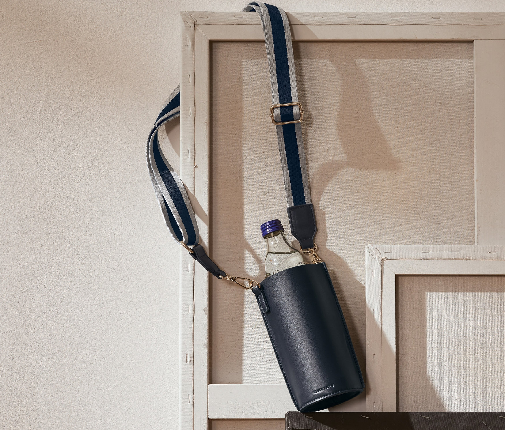 Eine dunkelblaue Bottle-Bag hängt an einem Bildrahmen.