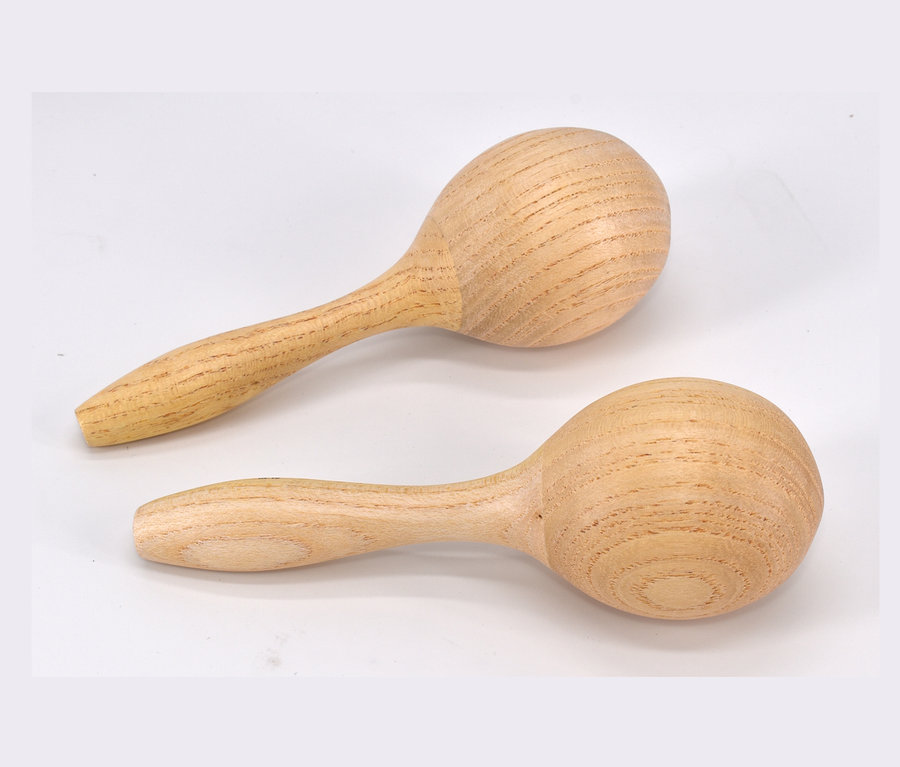 Zwei hölzerne Kinder-Maracas aus dem Voggenreiter-Kinder-Instrumente-Set liegen auf einer weißen Oberfläche.
