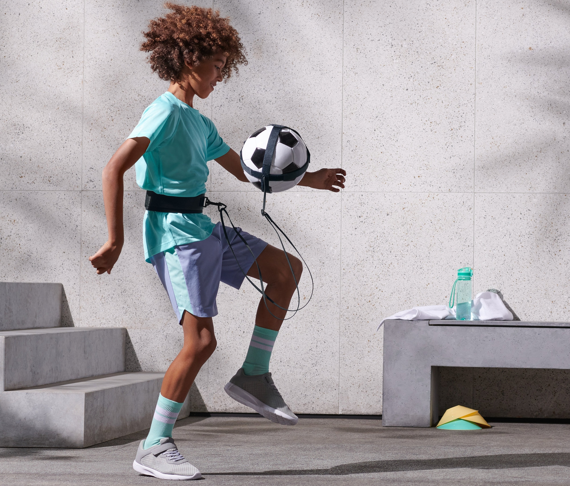 Junge trainiert mit dem Fußball-Rebound-Trainer.