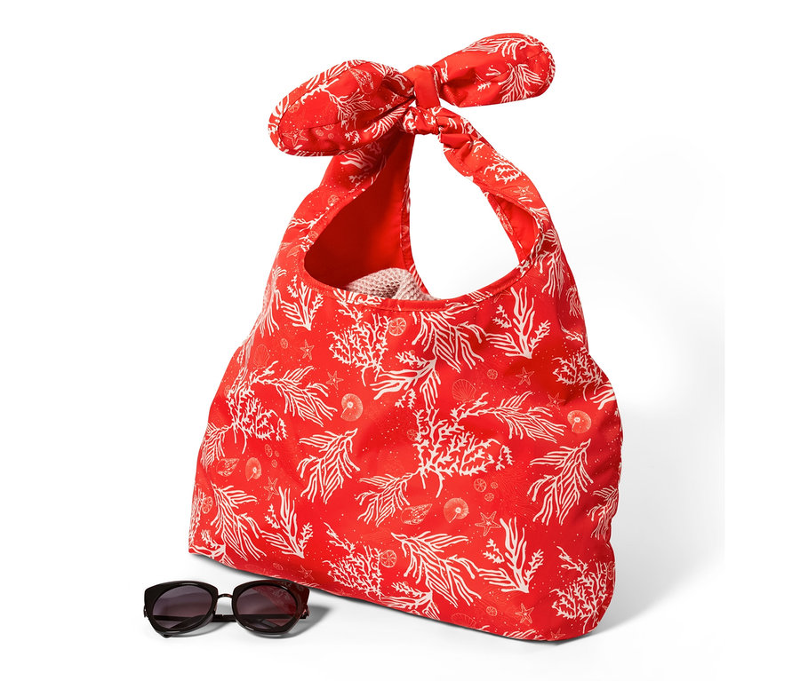 Eine faltbare Strandtasche mit rotem Korallenmuster und eine Sonnenbrille unten.