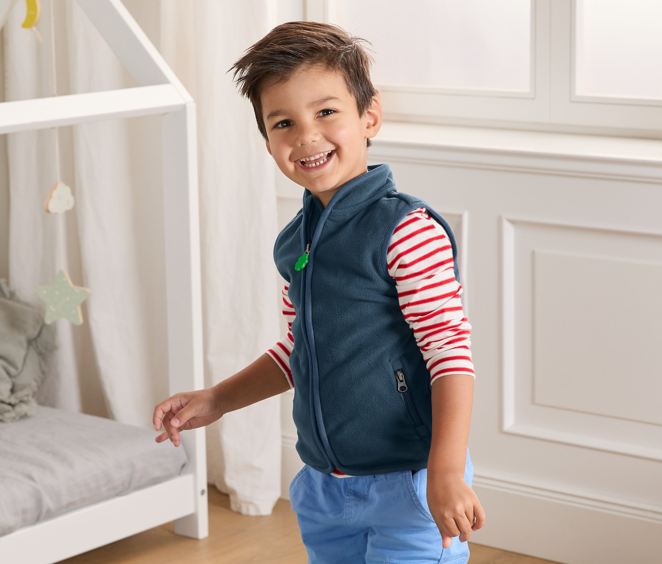 Lächelnder Junge trägt Fleeceweste aus recyceltem Material.