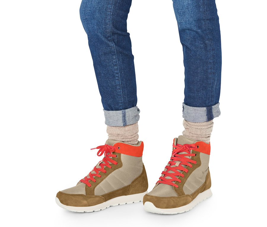 Beine in Jeans und Trekkingschuhen.