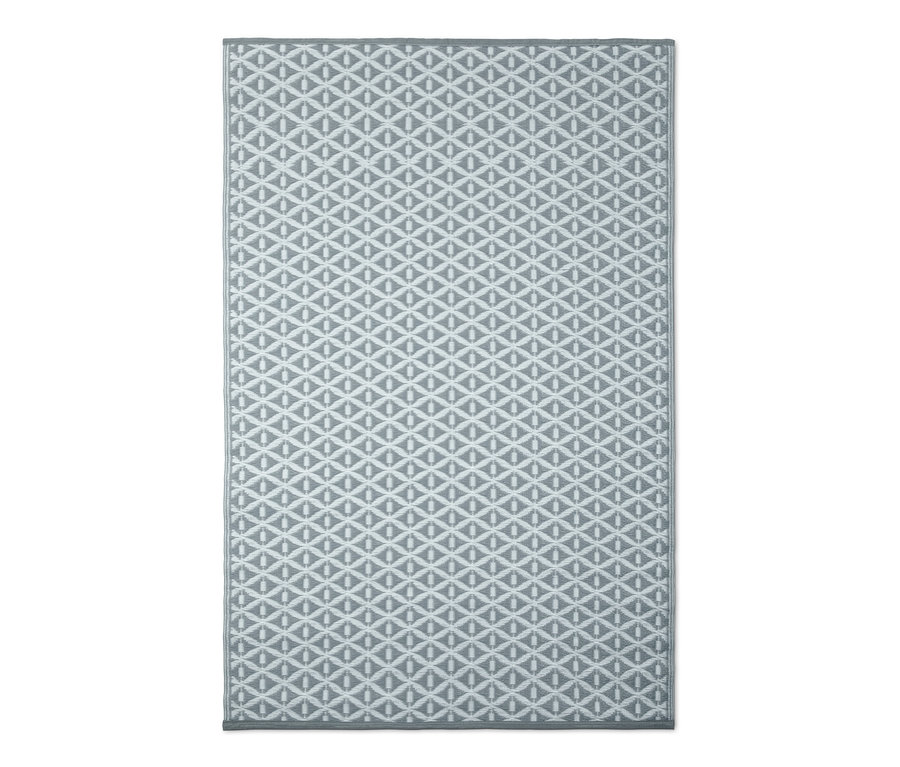Grauer Outdoorteppich mit geometrischem Muster.