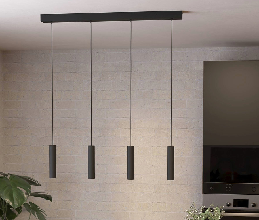 Vier schwarze, zylindrische Eglo Almudaina Pendelleuchten hängen über einem Holzesstisch.