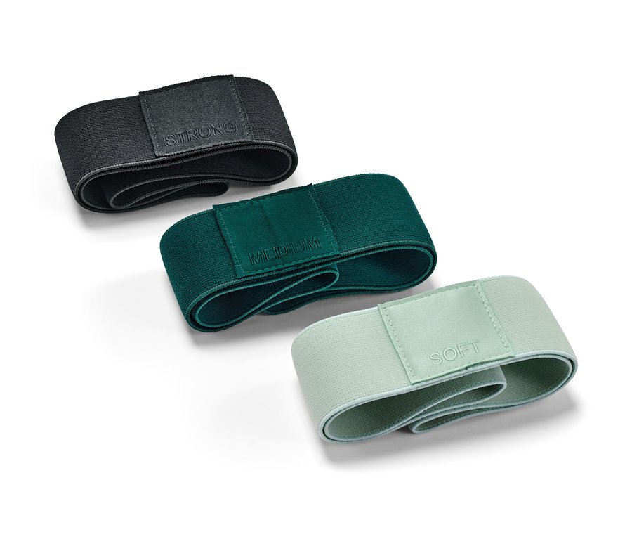 Drei Trainingsbänder in Schwarz, Grün und Hellgrün liegen auf einem weißen Hintergrund.