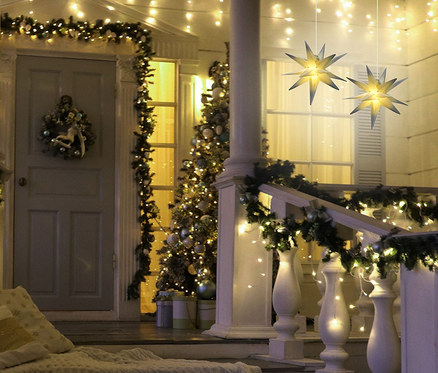 Beleuchtetes Haus mit Weihnachtsdekoration und zwei 27 cm AMARE LED-Sternen.