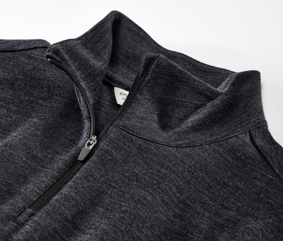 Detailaufnahme eines Funktionsshirts mit RWS-zertifizierter Wolle mit teilweise geöffnetem Reißverschluss.