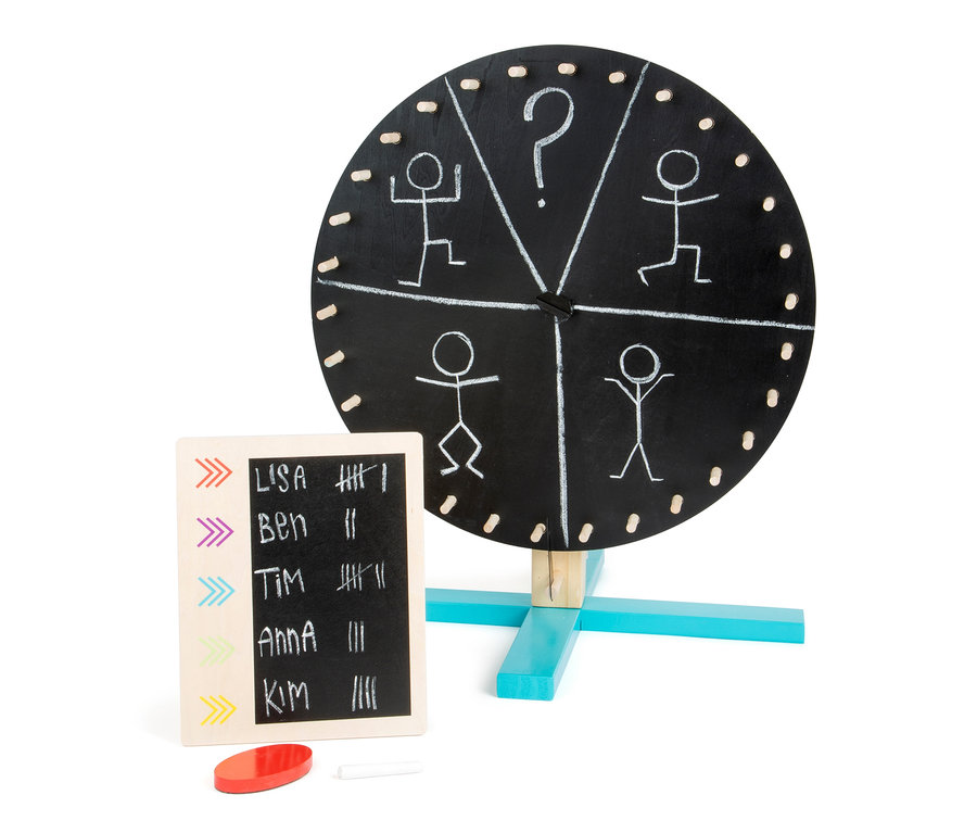 Ein schwarzes Glücksrad »Active« von small foot mit Strichmännchen-Zeichnungen und eine Tafel mit Namen und Strichen.
