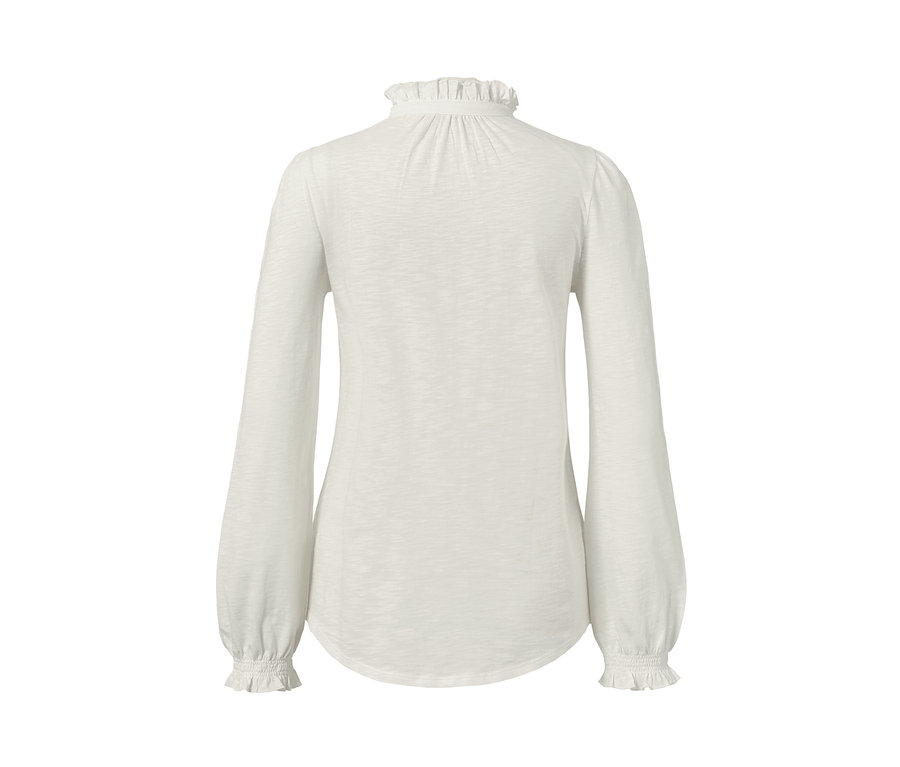 Detailansicht von hinten von einem weißen Langarmshirt mit Rüschen.