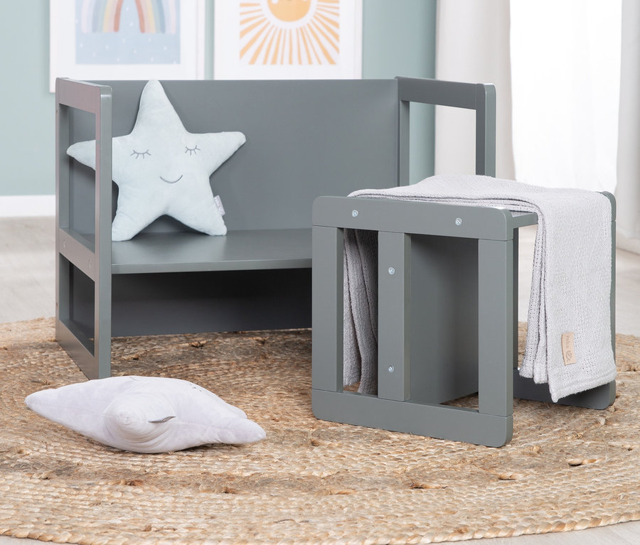 Eine anthrazitfarbene roba 3-in-1 Kindersitzgruppe mit Sternkissen und einer Decke auf einem runden Juteteppich.