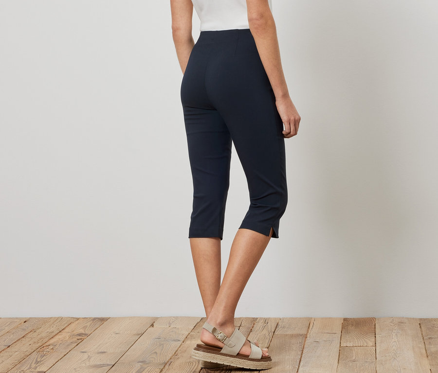 Frau trägt eine 3/4-Stretchhose in Navy und Sandalen.