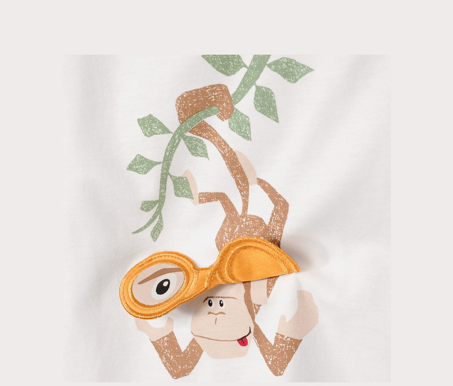 Grafik eines Kinder-T-Shirts mit einem Affen, der an einer Liane hängt und eine gelbe Brille trägt.