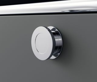 Detail einer grauen Metallkommode »CN3« mit rundem silbernem Griff.