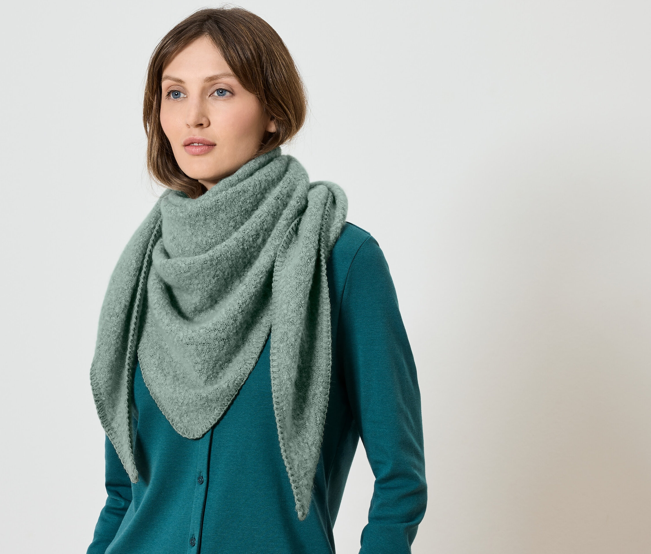 Frau trägt einen grünen Schal und einen grünen Pullover.