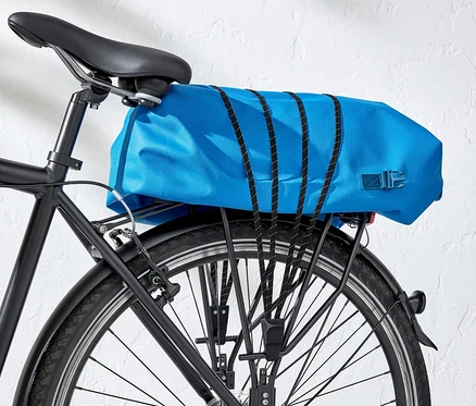 Detailaufnahme vom Hinterrad eines schwarzen Fahrrads mit einer blauen Gepäckträgertasche.