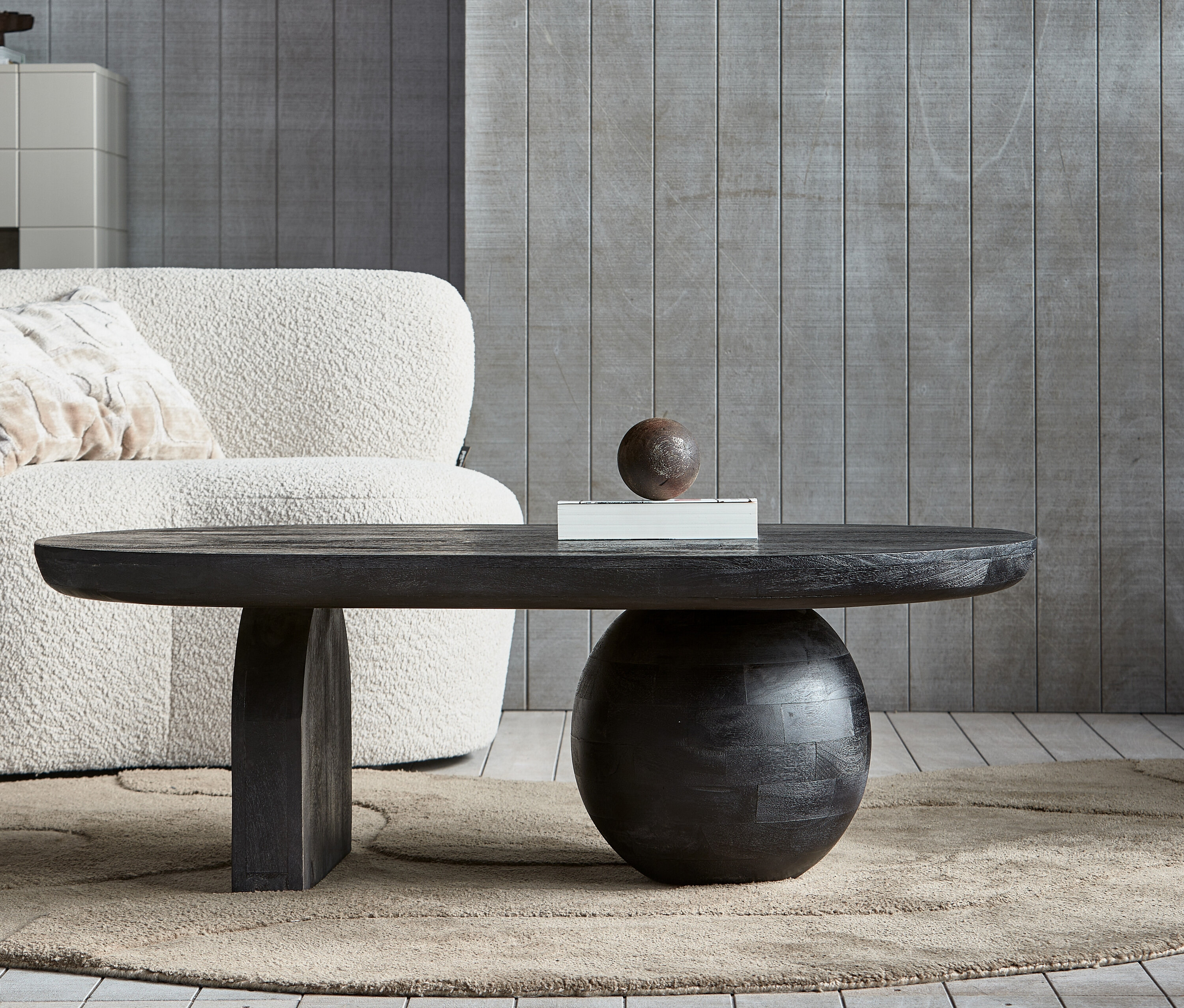 Schwarzer Woood Couchtisch Steppe auf beigem Teppich.