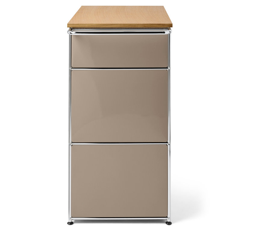 Ein Schrank mit drei beigen Schubladen, einer Holzplatte und einem Chromrahmen.