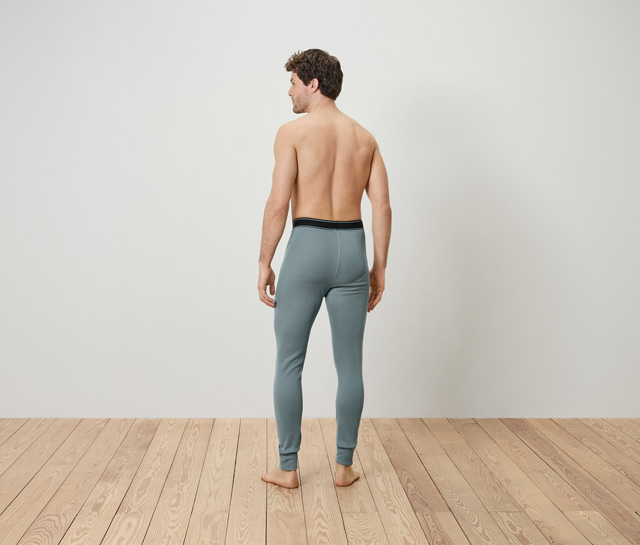 Ein Mann mit dem Rücken zur Kamera trägt graue Thermounterwäsche.
