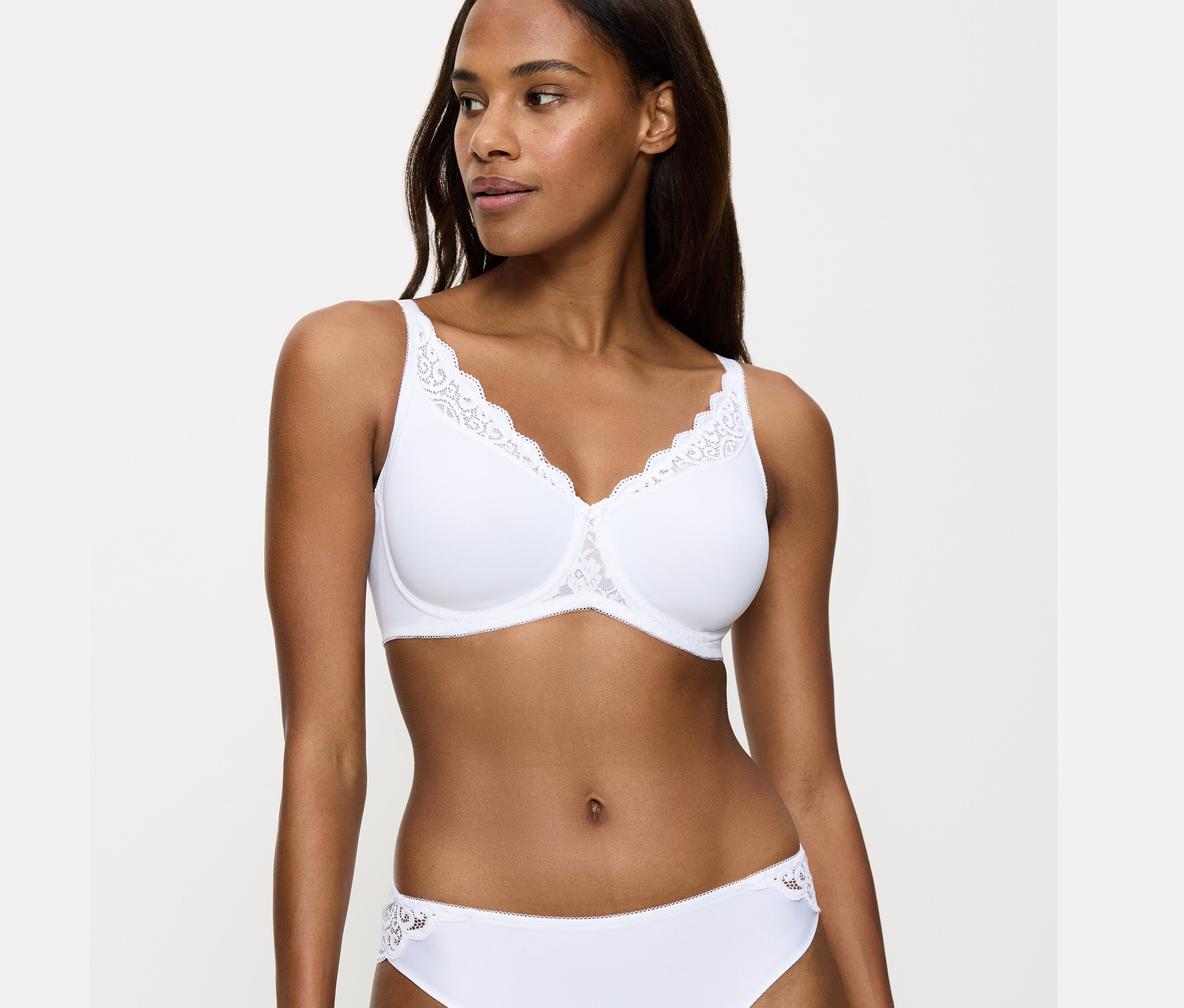 Frau trägt weißen Triumph Amourette Minimizer-BH.