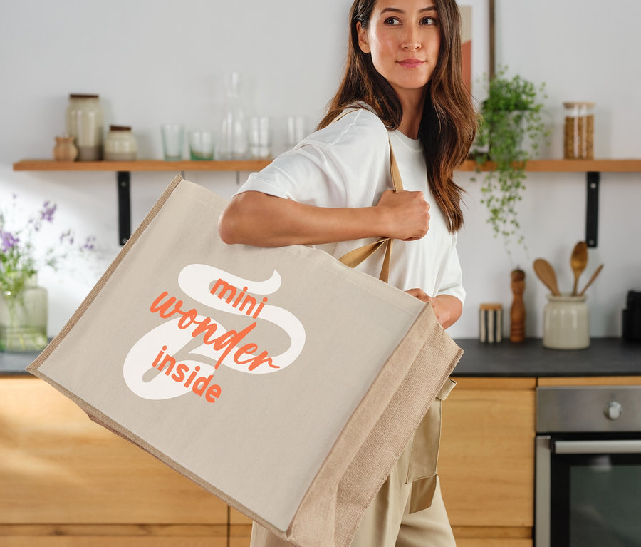 Frau trägt eine große Stofftasche mit der Aufschrift "mini wonder inside".