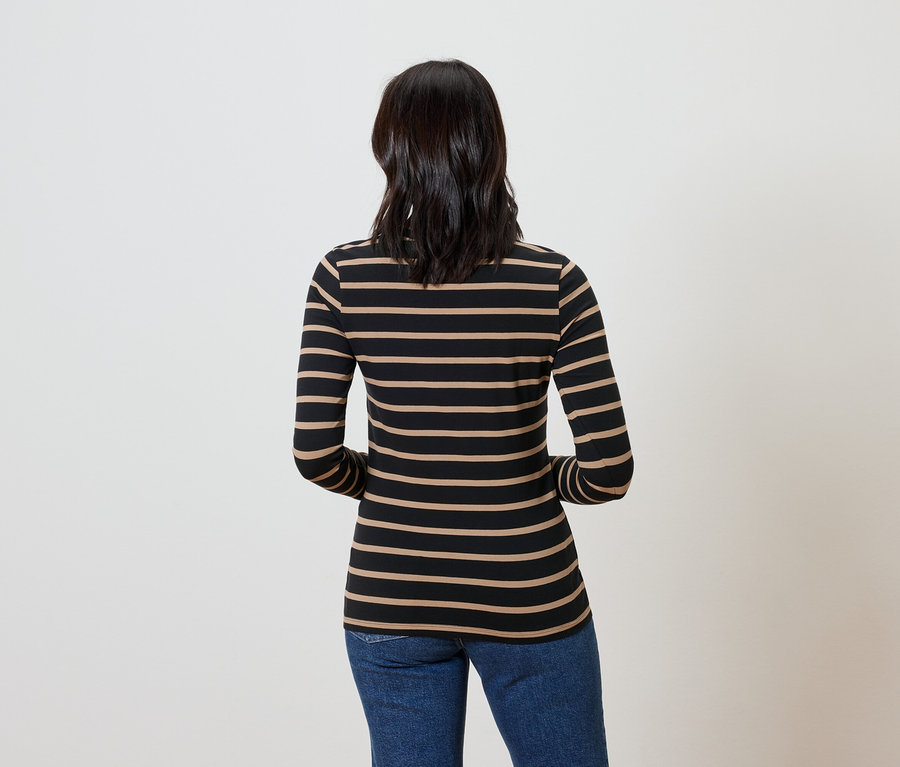 Rückansicht einer Frau mit dunklem Haar, die ein gestreiftes Langarmshirt und blaue Jeans trägt.