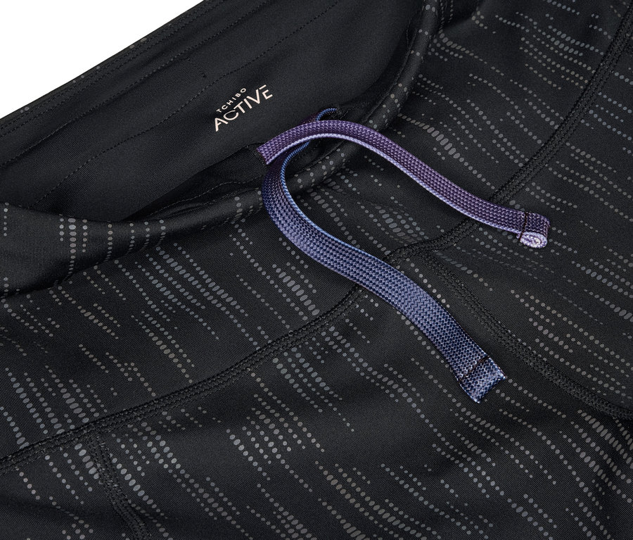 Detailaufnahme einer schwarz-grauen Sportleggings mit lila Kordelzug in der Taille.