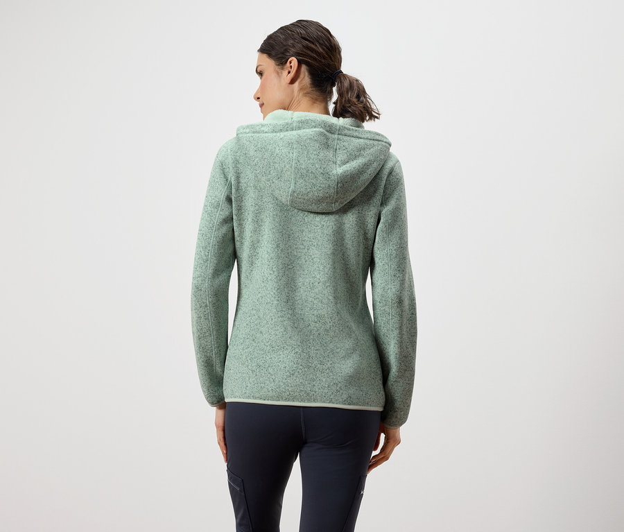 Rückansicht einer Frau in einem grünen Fleecepullover mit Kapuze und dunkelblauen Hosen.