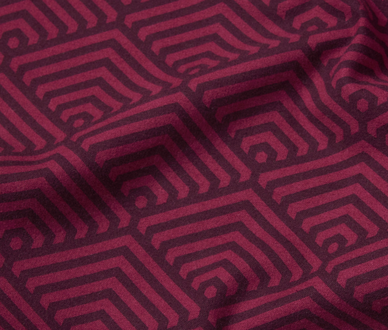 Nahaufnahme von bordeauxroter Biber-Bettwäsche in Normalgröße mit geometrischem Muster.