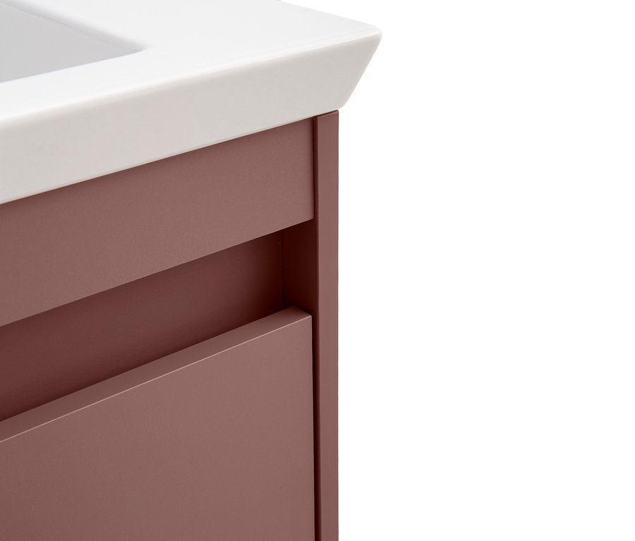 Detailansicht eines Badezimmerschranks mit Schubladen in Rosa und einer weißen Arbeitsplatte.