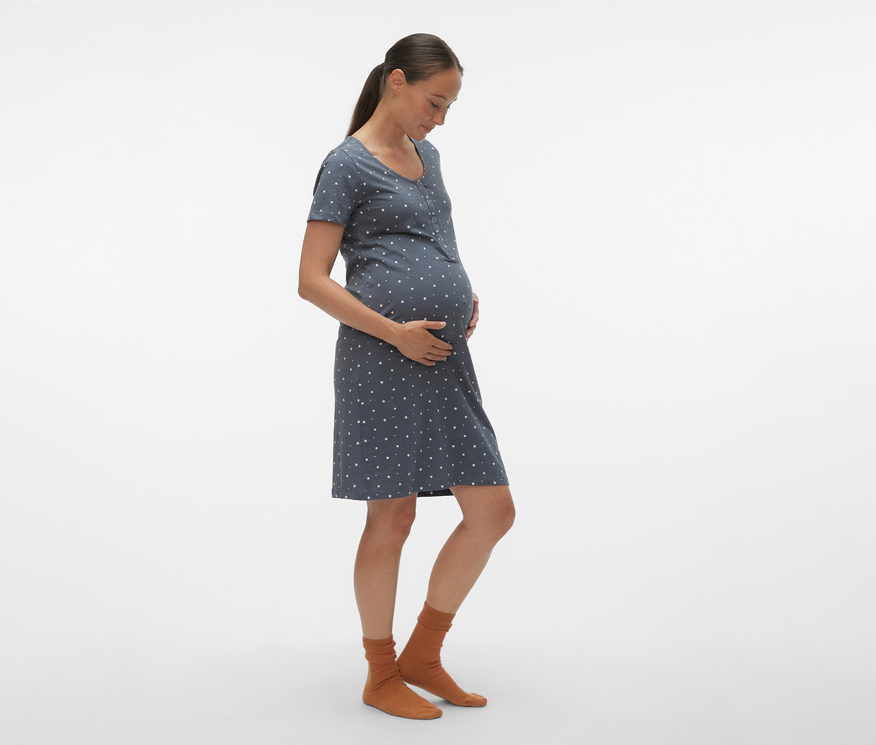 Schwangere Frau im Profil trägt ein blaues MAMALICIOUS Nachthemd »MLMIRA« mit weißen Punkten und braune Socken.