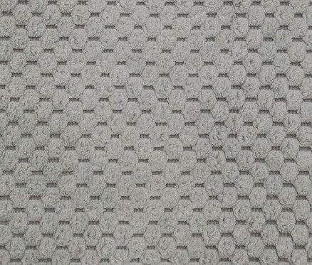 Nahaufnahme eines hellgrauen Teppichs mit geometrischem Muster.