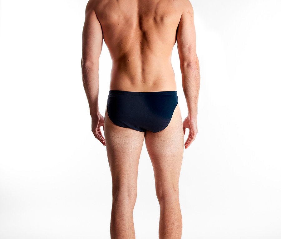 Mann von hinten, der eine dunkle Badehose trägt.