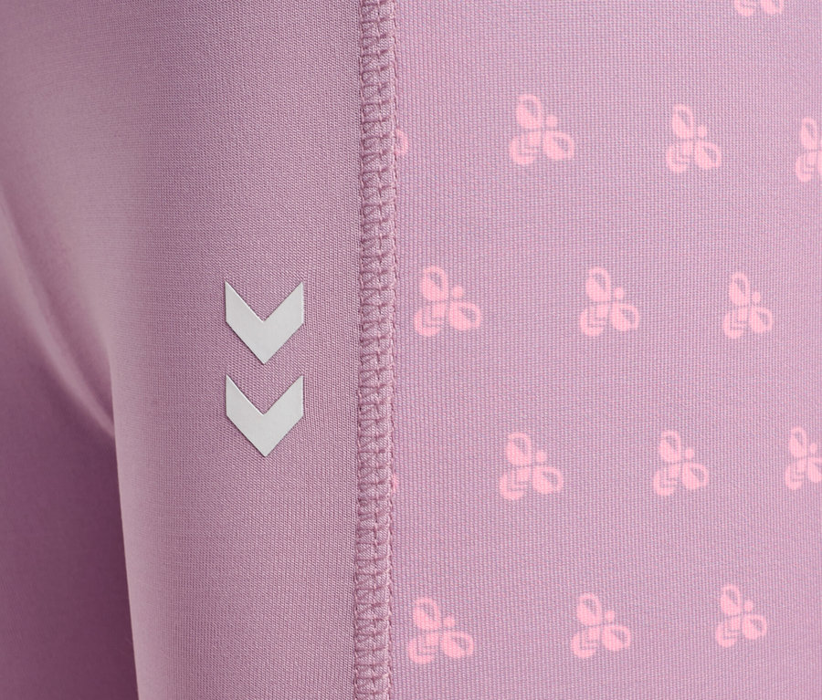 Nahaufnahme einer lila Leggings mit einem sich wiederholenden Muster und dem Winkel-Logo an der Seite.