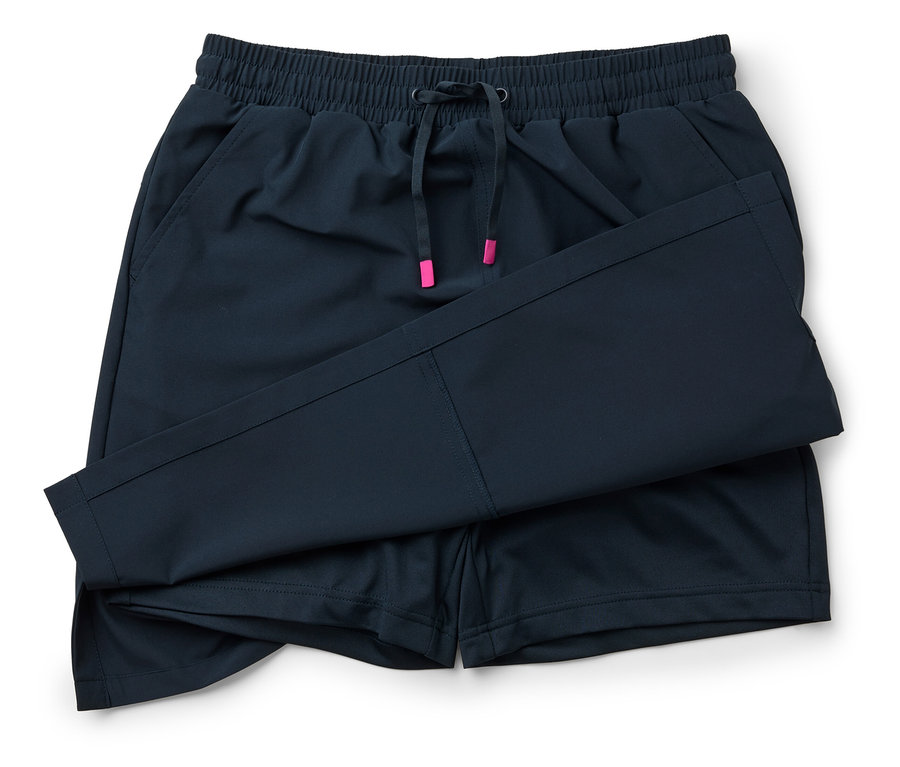 Nahaufnahme einer marineblauen Shorts mit Kordelzug und pinkfarbenen Akzenten, die auf einem weißen Hintergrund liegt.