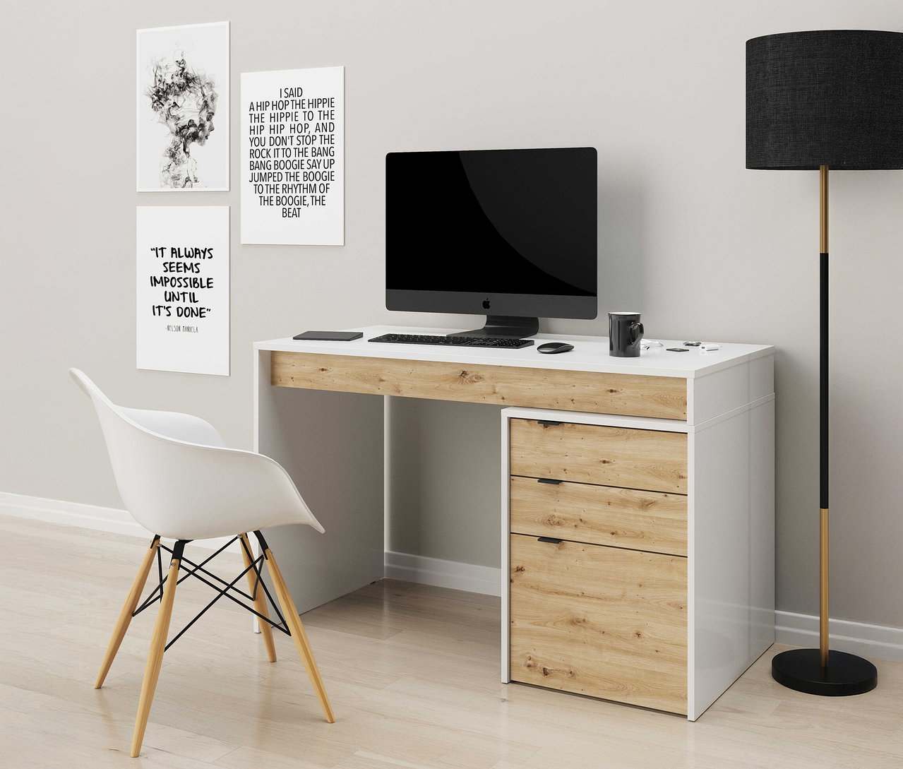 Weißer Schreibtisch mit Computeraufbau und Stuhl. An der Wand hängen drei gerahmte Kunstdrucke.