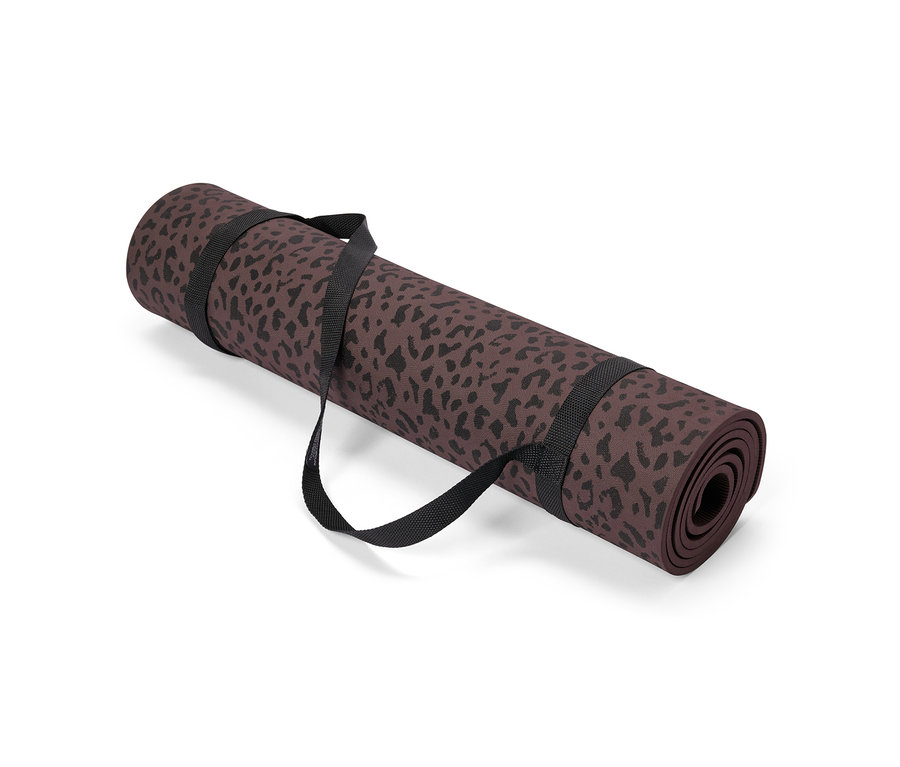 Eine zusammengerollte, braune Yogamatte mit schwarzem Leopardenmuster wird von einem schwarzen Gurt gehalten.