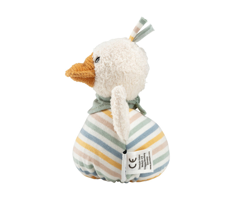 Weißes Plüschtier in Form eines Vogels mit orangefarbenem Schnabel, kleinen schwarzen Augen und grünem Schal. Der runde Körper hat hellblaue, gelbe, grüne und orangefarbene Streifen. Kleine weiße Flügel und ein Stoffetikett sind am Rücken, gestreifte Stoffstücke auf dem Kopf.
