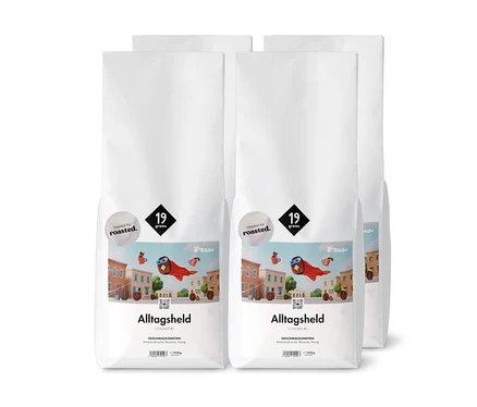 Vier weiße Tüten Tchibo Alltagsheld Kaffee CO-ROAST #3 mit Amarenakirsche, Brownie und Honig Geschmack, geröstet für 19 Gramm.