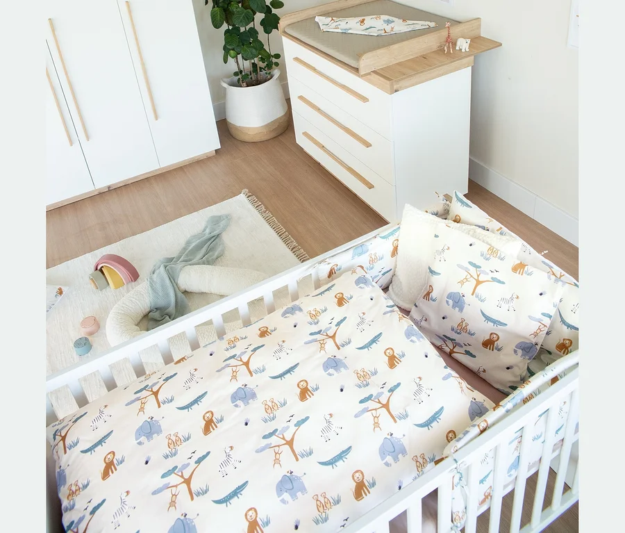 Roba 2-teiliges Kinderzimmer-Set »Lumo«: weißes Gitterbett mit Tiermotiv-Bettwäsche und Wickelkommode. Dazu Schrank, Teppich mit Spielzeug und Pflanze.