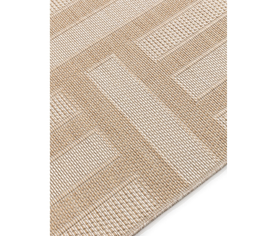 Schräge Nahaufnahme eines beigen gewebten Teppichs mit strukturiertem Chevron-Muster.
