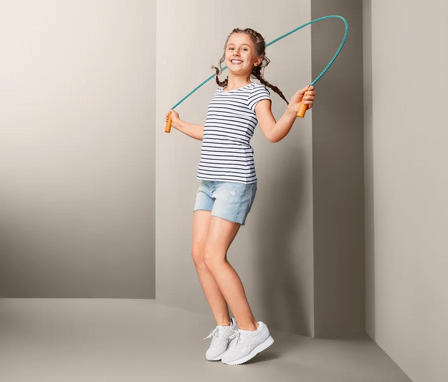 Mädchen springt mit einem Springseil.