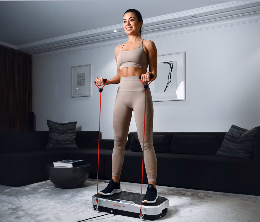 Frau trainiert mit Christopeit Vibrationstrainer Vibro VBT 4200 und roten Widerstandsbändern.