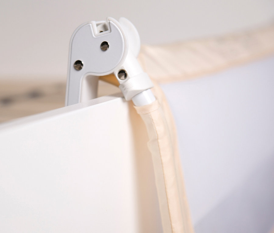 Detail einer Ecke eines weißen Kinderbetts mit beigem roba Bettschutzgitter »Klipp-Klapp«.