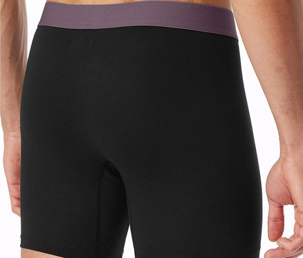 Mann von hinten, trägt schwarze Boxershorts mit lila Bund.