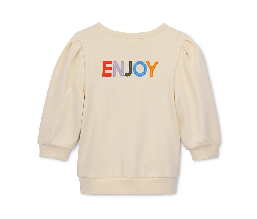Ein cremefarbenes Cropped-Sweatshirt mit dem Wort "ENJOY" in Regenbogenfarben.