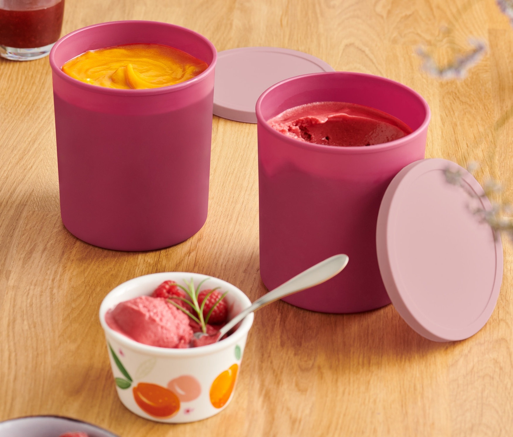 Zwei gefüllte Gefrierbehälter mit Deckel auf einem Holztisch.