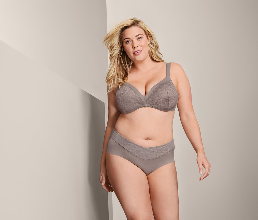 Blonde Frau trägt ein beiges Dessous-Set mit einem Softschalen-BH.