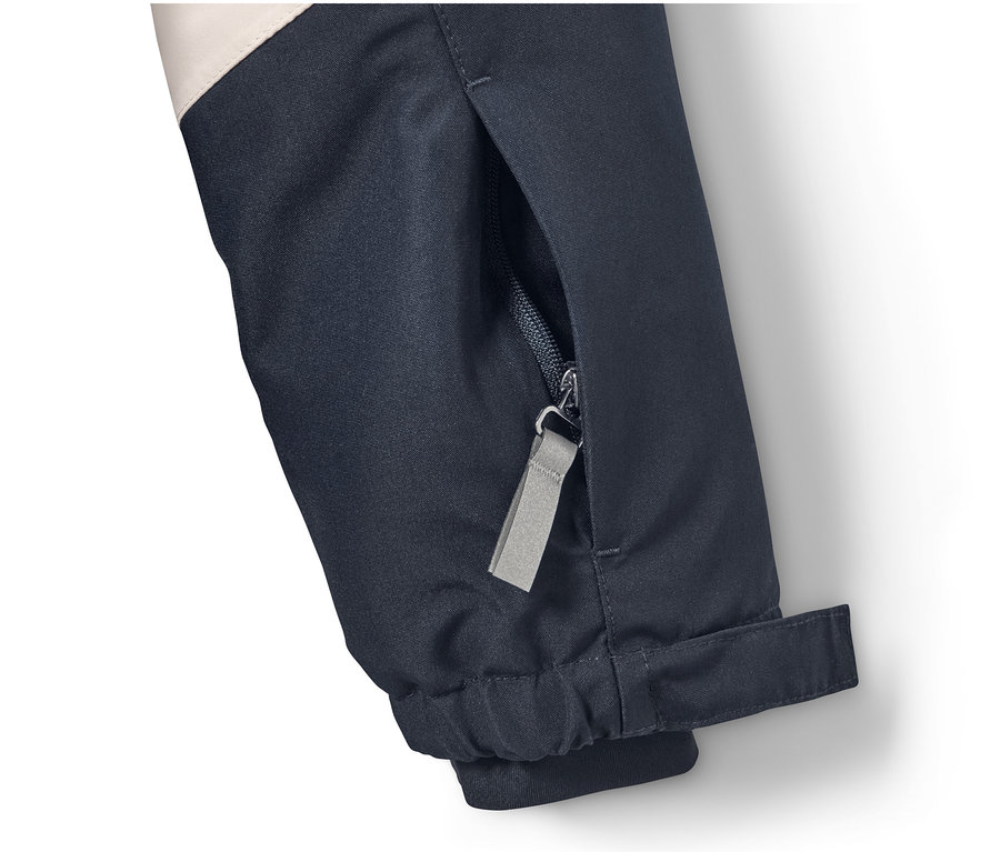 Detailansicht einer Skijacke mit Reißverschlusstasche.