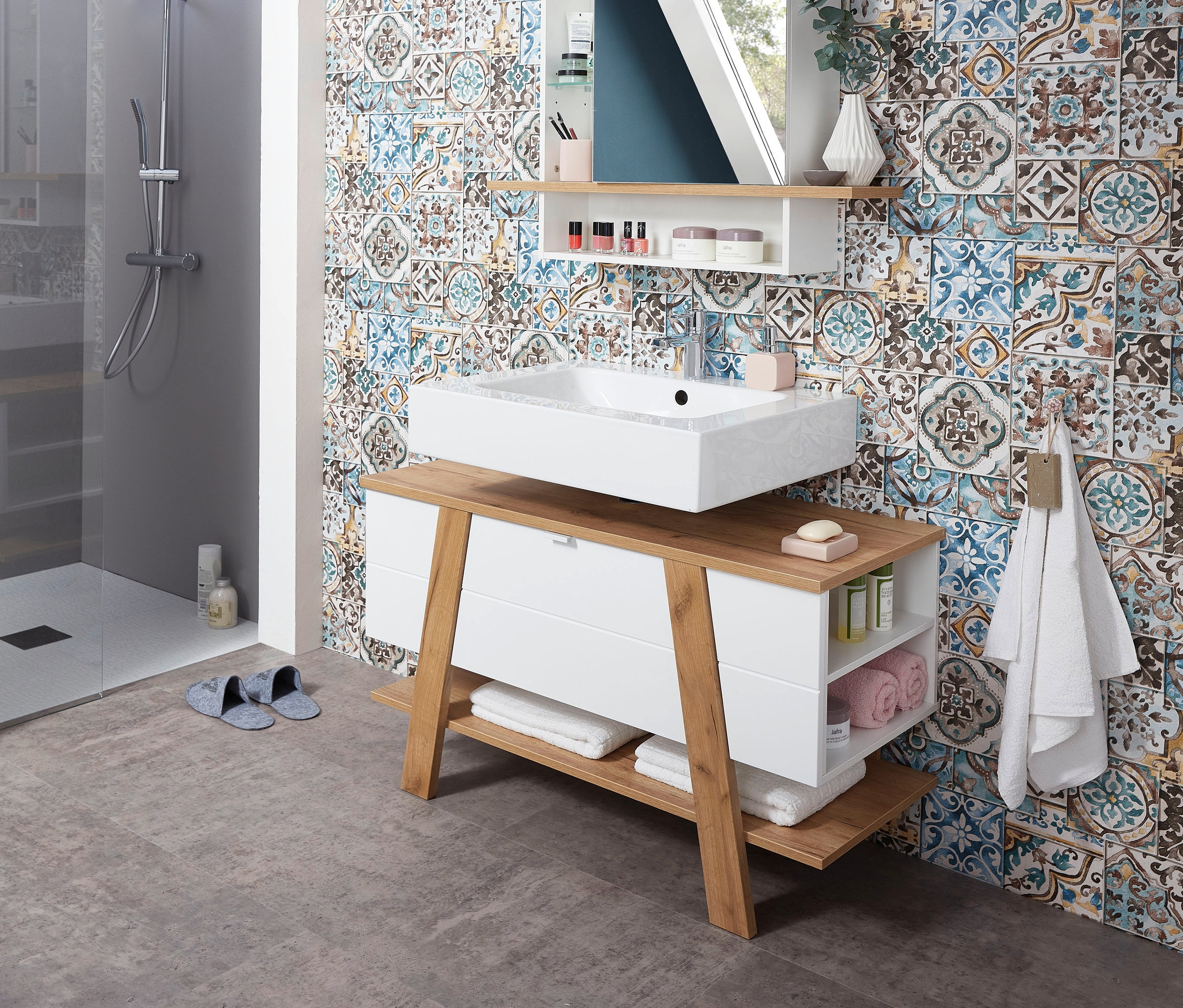 Badezimmer mit Novolino Waschbeckenunterschrank und Spiegelschrank.