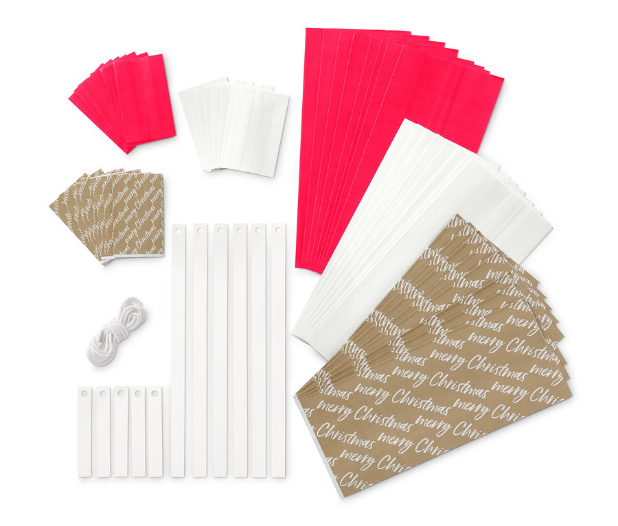 Papiertüten-Sterne-Bastel-Set: Rote, weiße und braune Papiertüten mit der Aufschrift "Merry Christmas", weiße Stäbe und eine Kordel.